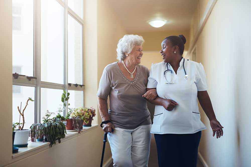 Elderley lady with her carer in a corridor