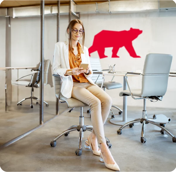 woman sitting on a stool in an office with the almas bear on the wall behind